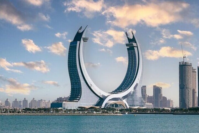 A futuristic bridge with a curved design, a city skyline in the background, and a body of water in the foreground. 2