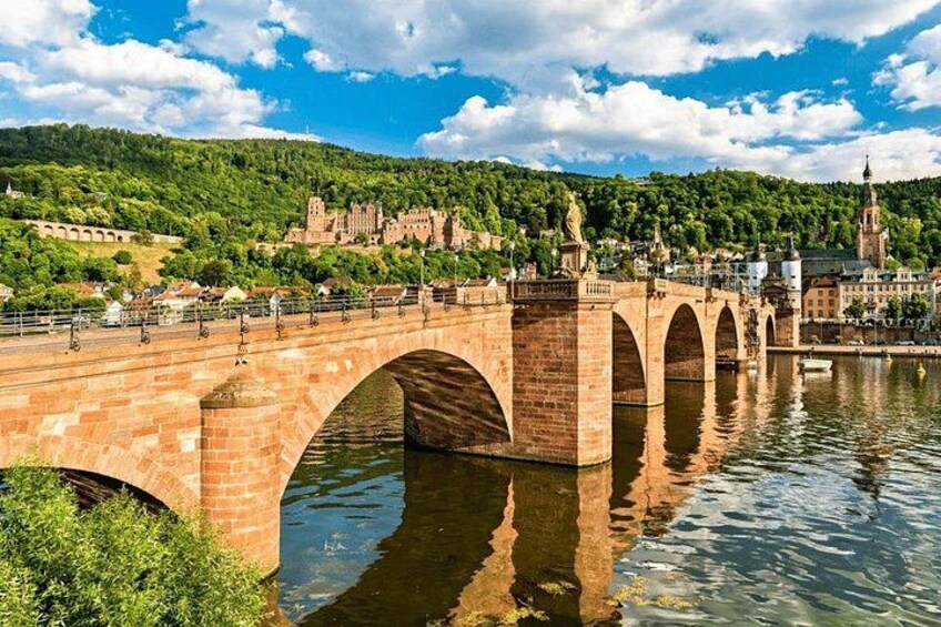 A stone bridge over a river with a castle in the background. 4