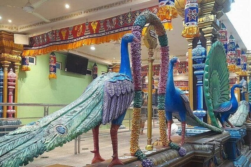 A colorful peacock sculpture with intricate designs and a peacock feather. 5