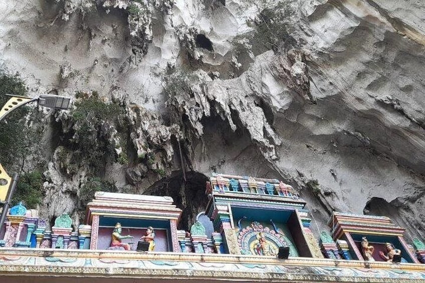 A temple with colorful carvings and statues against a rocky cliff backdrop. 4