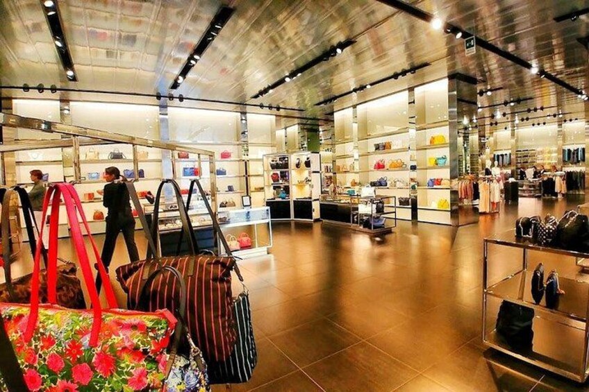 En rummelig butik med hylder fyldt med tasker og accessories. 3