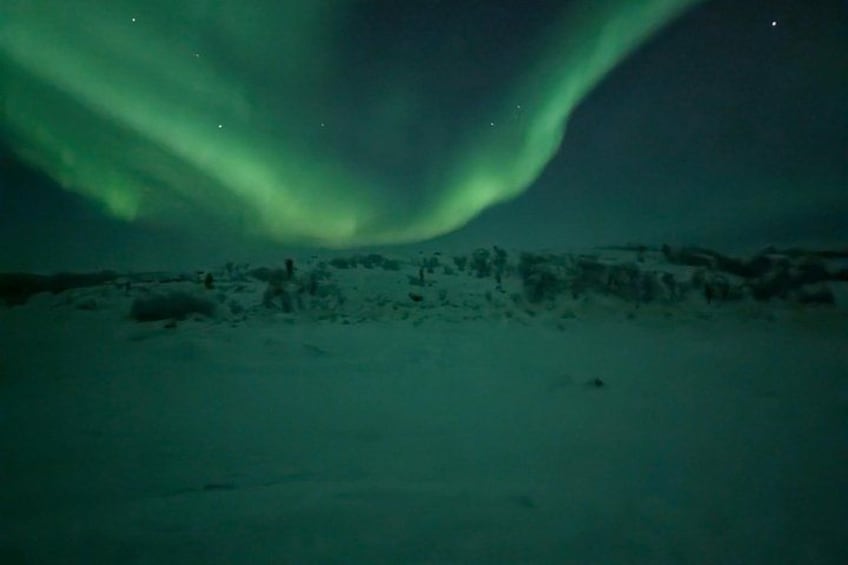 Des aurores boréales au-dessus d'un paysage enneigé. 3