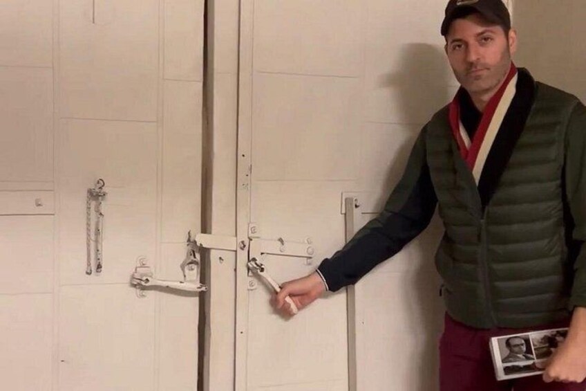 A person standing next to a door with a lock and a key. 2