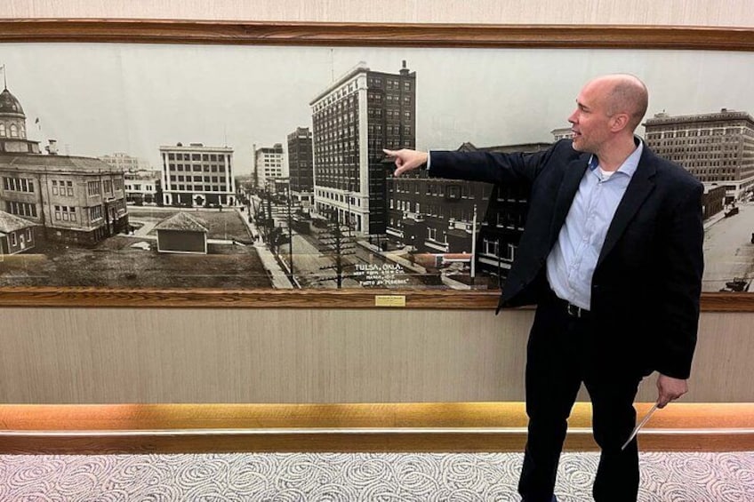 Ein Mann zeigt auf ein Gemälde einer historischen Stadtansicht. 3