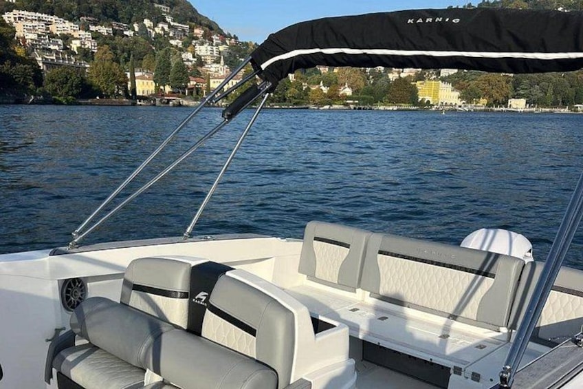 A boat with a canopy, water, and a distant shoreline with buildings. 5