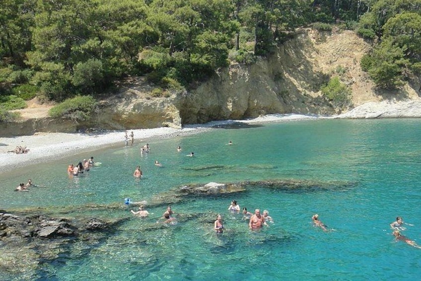 Eine Küstenlandschaft mit klarem türkisblauem Wasser, Felsformationen und einem Sandstrand. 5