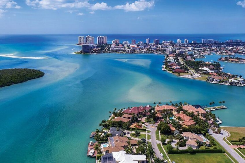 Un paysage urbain côtier avec un port de plaisance, des zones résidentielles et une mer bleue et limpide. 1