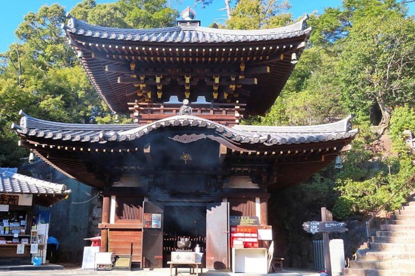 A traditional Japanese pagoda with a curved roof and multiple tiers, surrounded by lush greenery. 5