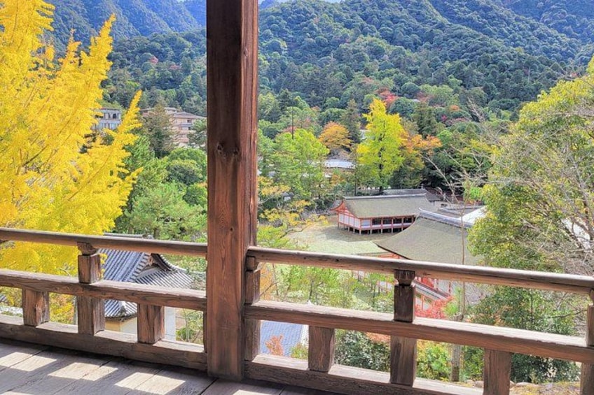 A traditional Japanese building with a tiled roof, surrounded by autumn-colored trees and a mountainous landscape. 4