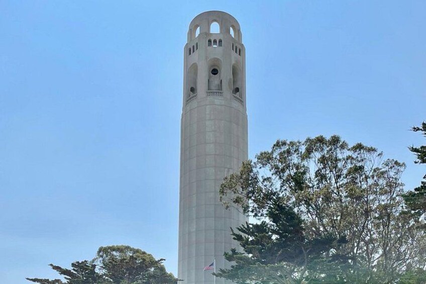 A tall, cylindrical tower with arched openings at the top, surrounded by trees. 1