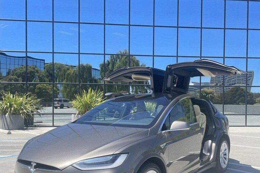 A car parked in front of a building with large glass windows. 2