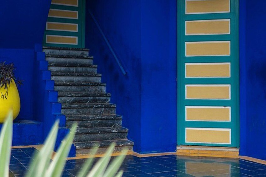 Een trap met blauwe muren en een gele plant. 2