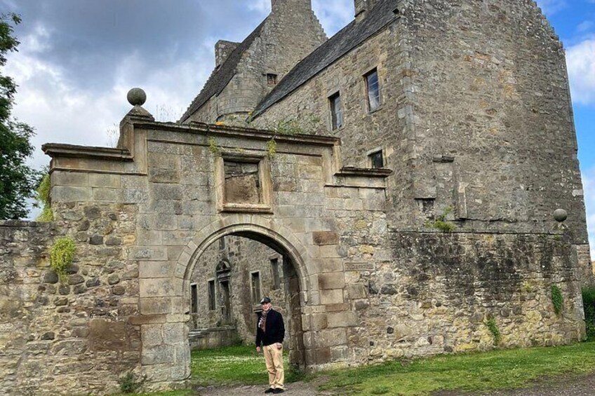 A stone castle with a large arched entrance and a person standing in front. 4
