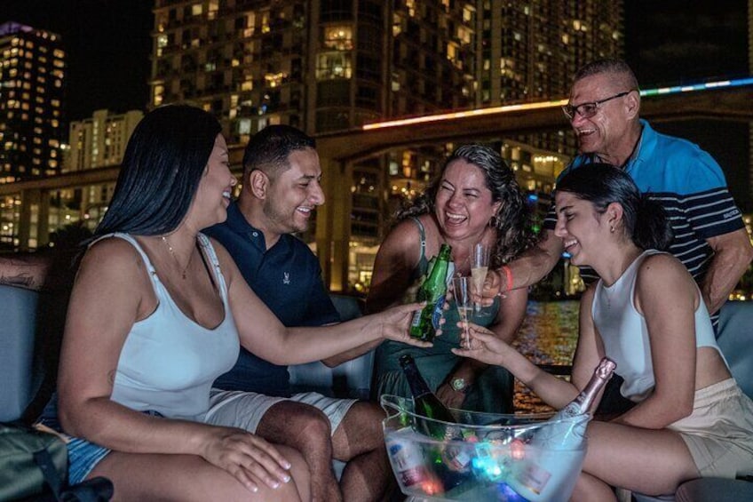 Un grupo de personas brindando con bebidas en una azotea con el horizonte de una ciudad al fondo. 4