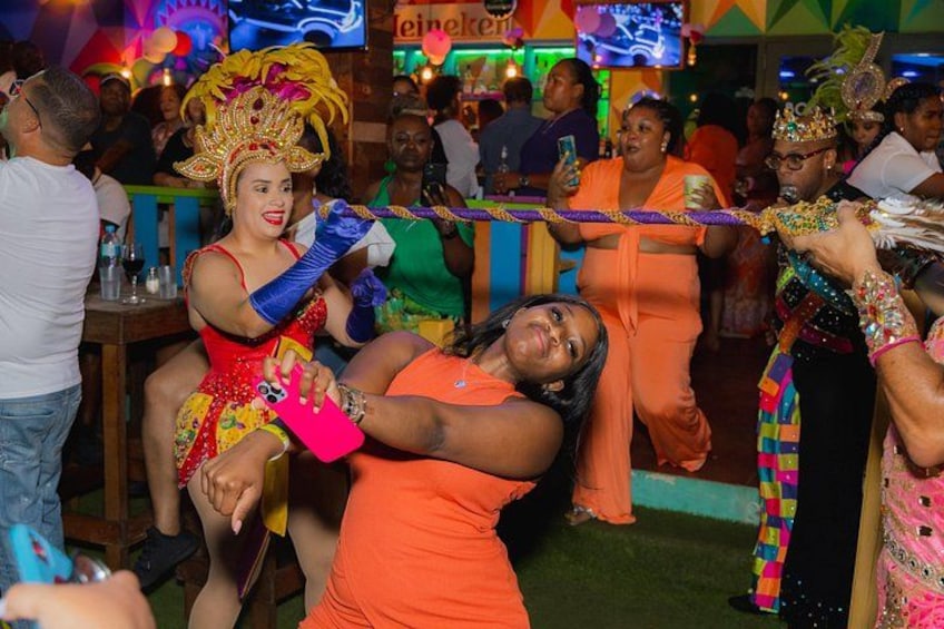 A lively indoor event with people dancing and wearing colorful costumes. 4