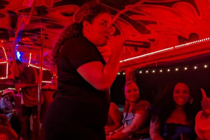 A person speaking into a microphone in a dimly lit room with red lighting. 5