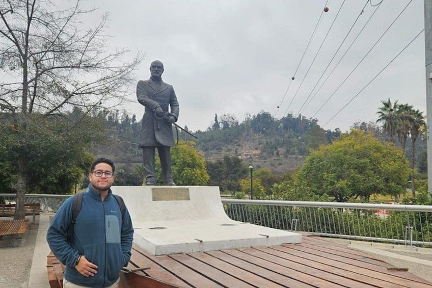 A person standing in front of a statue on a wooden platform with a hilly landscape in the background. 5