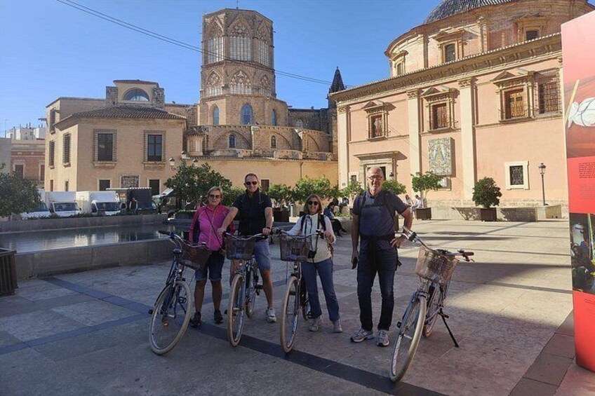 Un grupo de personas con bicicletas frente a un edificio histórico con una torre. 4