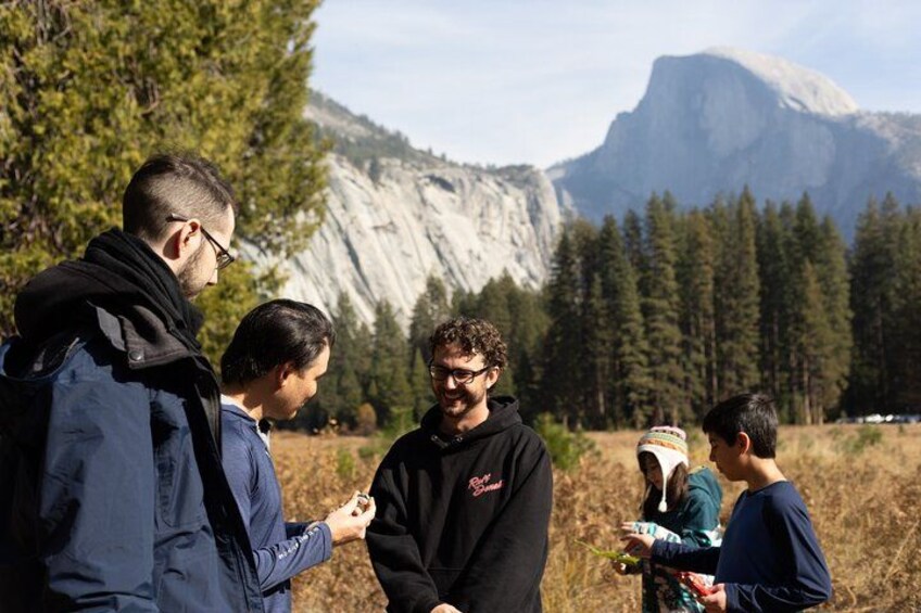 A group of people standing outdoors with a mountainous landscape in the background. 4