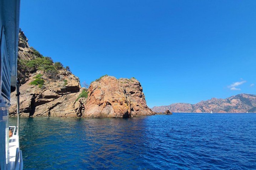 A rocky coastline, calm sea, and distant mountains. 4