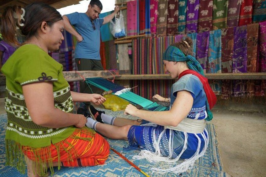 Two individuals engaged in textile work, surrounded by colorful fabrics and tools. 5