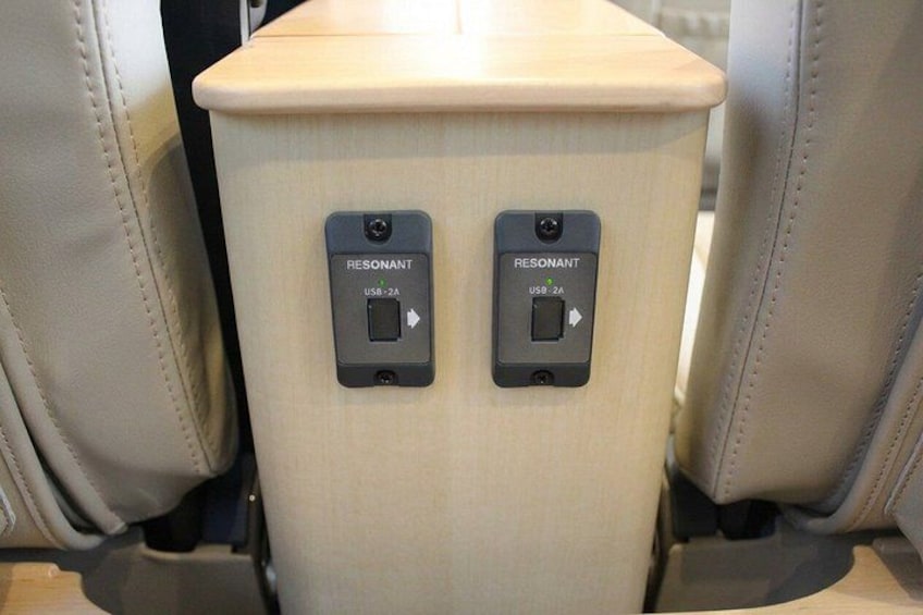 A seatback with two USB 2.0 ports labeled 'RESONANT' and a control panel with a button and a display. 2