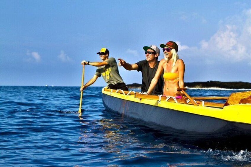 Una pequeña embarcación amarilla en el agua con tres personas. 2