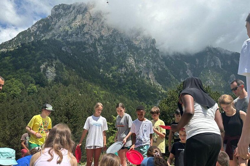 A group of people standing outdoors with a mountainous landscape in the background. 2