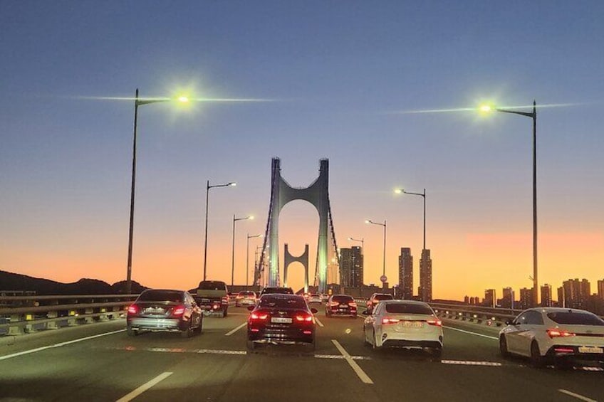 A bridge with vehicles on a highway during sunset. 2