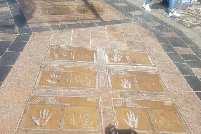A tiled pavement with handprints and text. 5