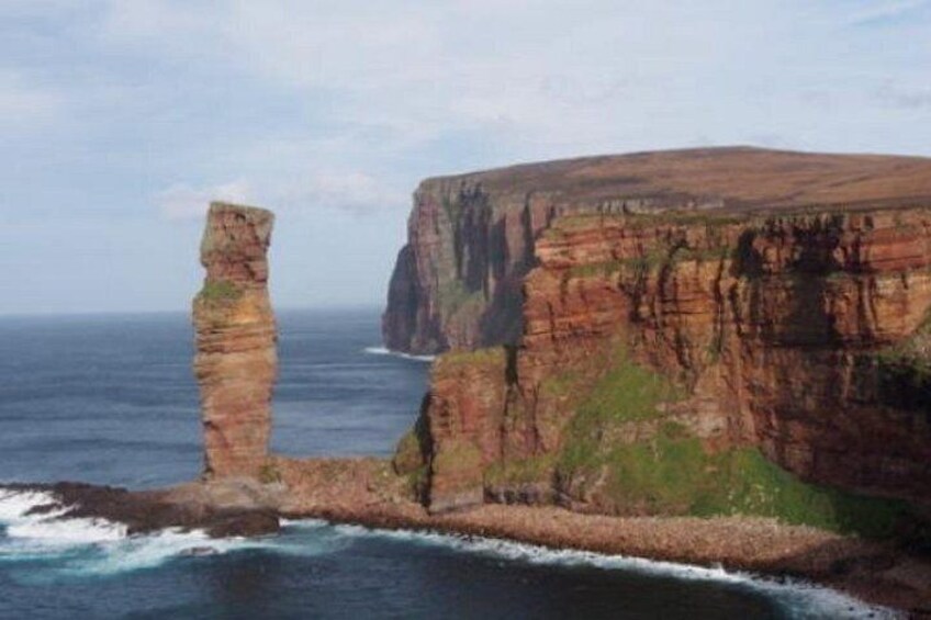 Une falaise côtière surmontée d’une formation rocheuse remarquable. 3