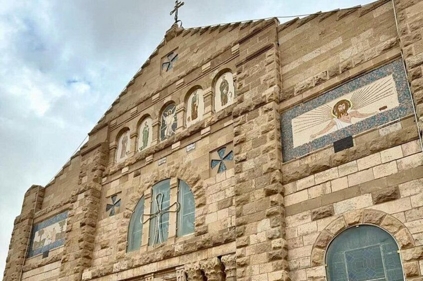 Un edificio histórico de piedra con ventanas arqueadas y detalles en mosaico. 1
