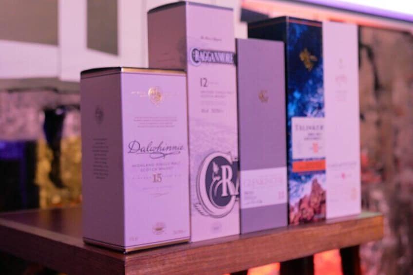 A row of whisky boxes on a shelf. 3