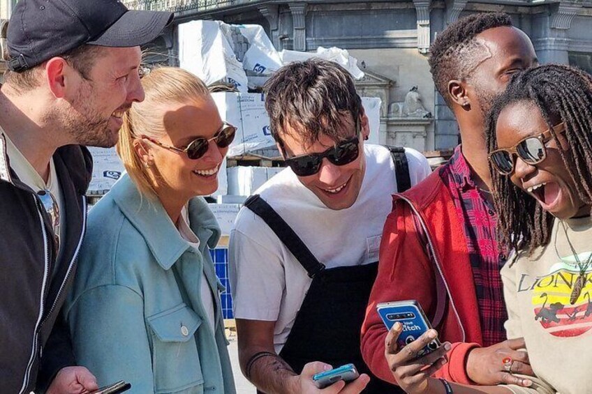 Un groupe de personnes se tient à l’extérieur, et certaines d’entre elles regardent leur téléphone. 3