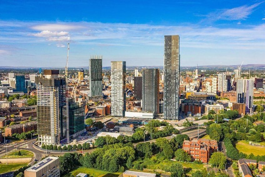 A cityscape with modern skyscrapers, a mix of greenery, and a clear sky. 2