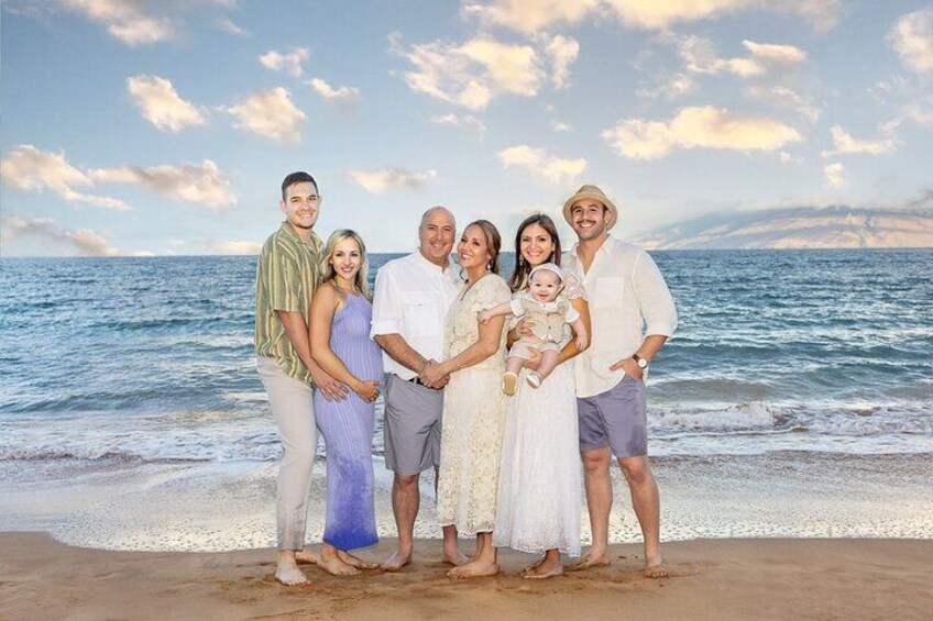 Una familia de siete personas en una playa, con el océano al fondo. 1