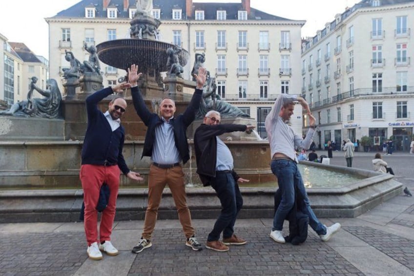 A group of people posing in front of a fountain with a statue in the background. 4
