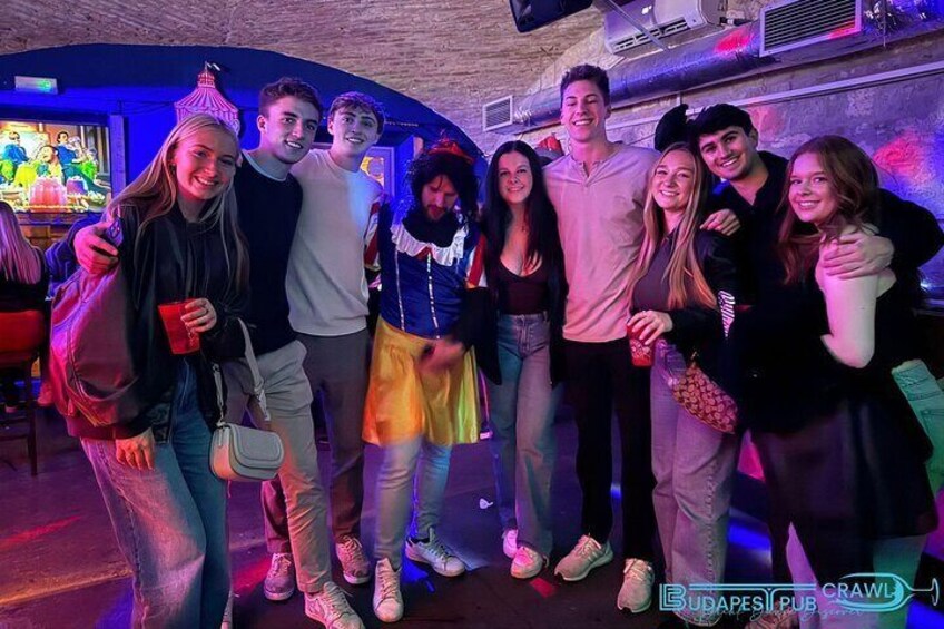 Eine Gruppe von Menschen in einer Bar mit Wandgemälde. 1