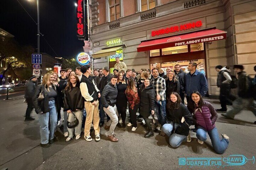 Eine Gruppe von Menschen posiert vor einem Burger King Restaurant in der Nacht. 4