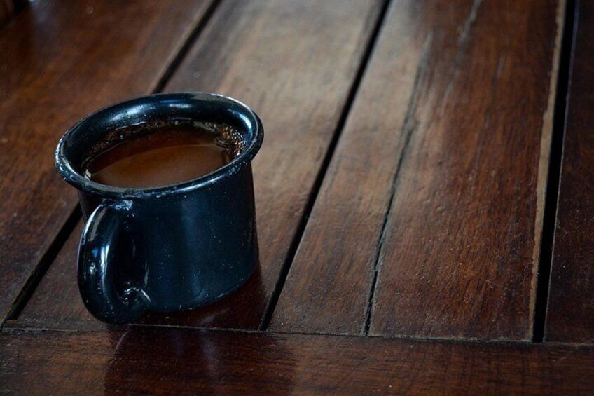 A dark blue mug with a handle on a wooden surface. 5