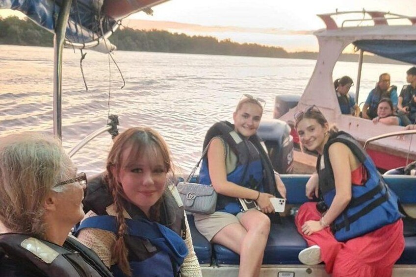 A group of people on a boat with water in the background. 4