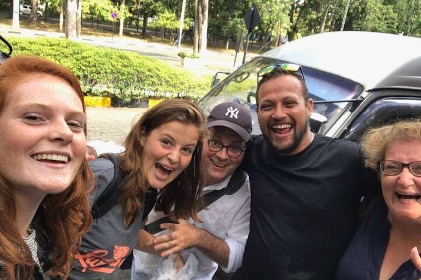 Eine Gruppe von Menschen posiert vor einem Auto. 1