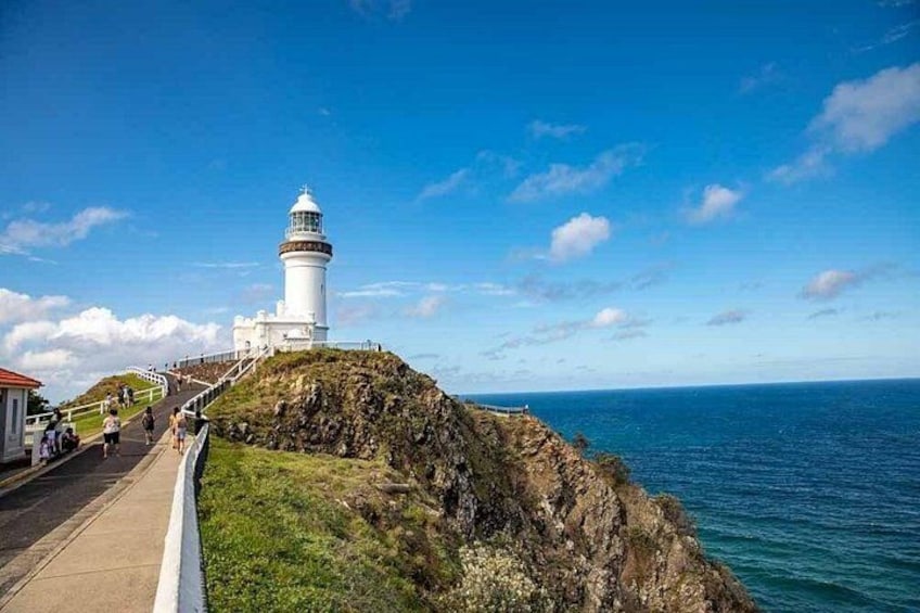 A lighthouse on a rocky cliff with a clear blue sky. 2