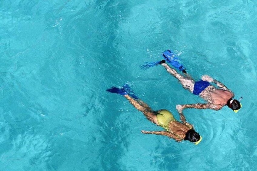Two people swimming in a pool. 2