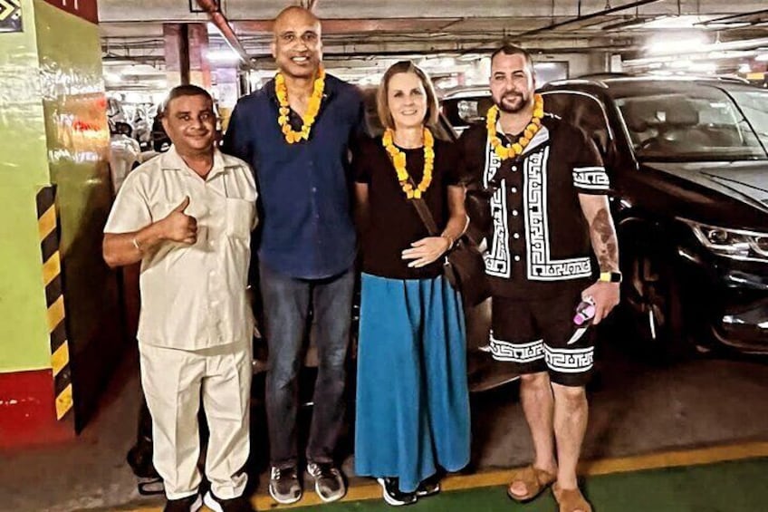 Vier Personen stehen in einer Parkgarage, im Hintergrund sind Autos zu sehen. 1