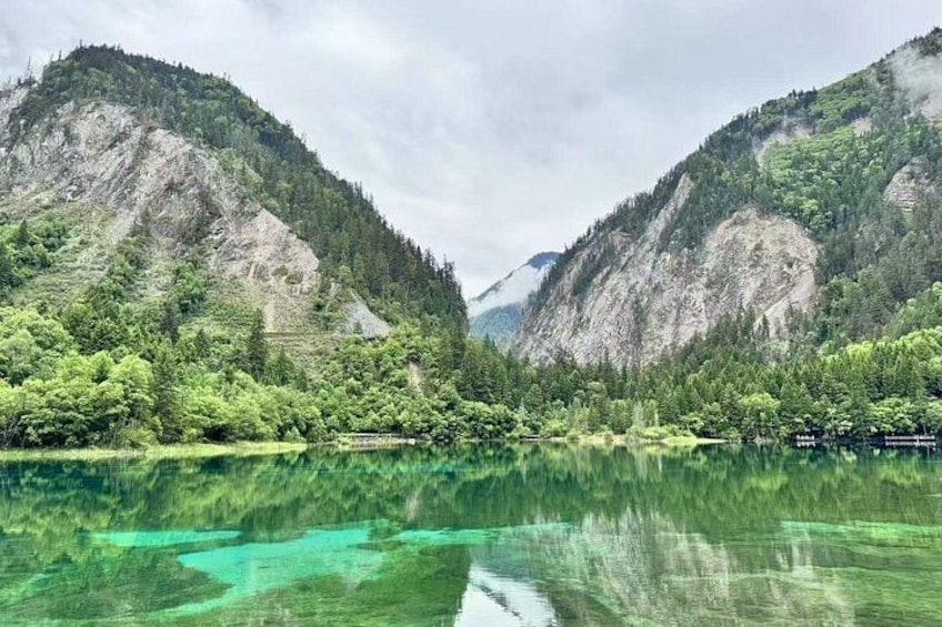 A mountain landscape with a clear lake reflecting the greenery. 5