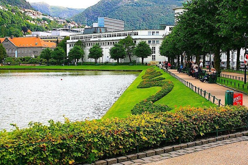 A lake with a well-maintained grassy area and a pathway along the water's edge. 2