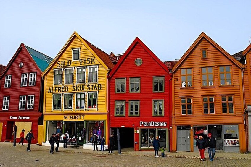 Colorful buildings with signs, including 'SILD-FISK' and 'ALFRED SKULSTAD'. 3