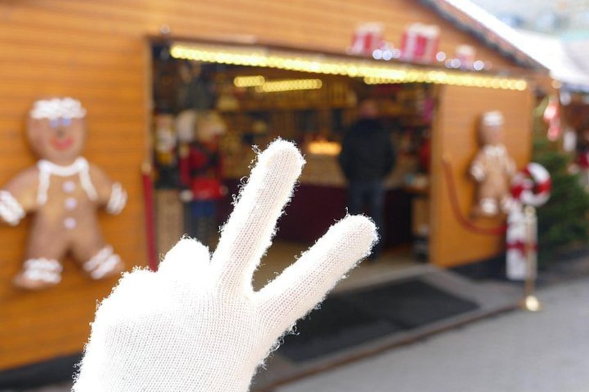 En pepparkaksgubbe, en butiksfasad och en hand som gör fredstecknet. 1