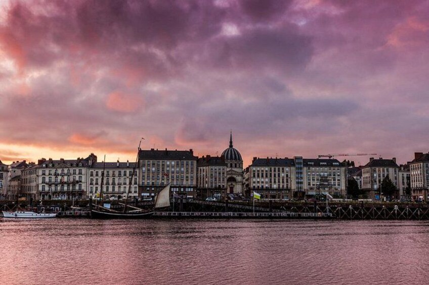 En stadsbild vid vattnet med historiska byggnader, en framträdande kupolformad byggnad och en bro. 3